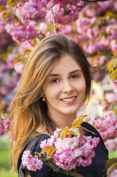 Chica feliz en las flores de sakura — Foto de Stock