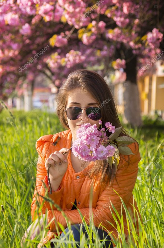 beautiful girl smelling a pink sakura flowers