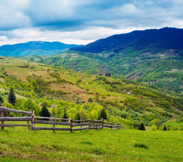 Fence on hillside meadow in mountain — Stock Photo, Image