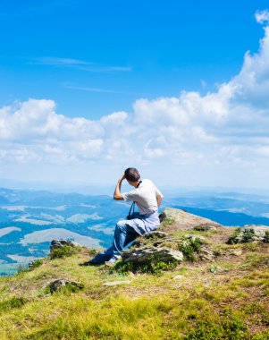 oturma ve dağlar arayan adam