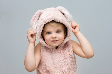 happy girl in a vest with Easter bunny ears is looking at the camera. Traditions for Easter. Positive emotions.