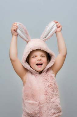 Paskalya tavşanı kulaklı, yelekli mutlu kız. Paskalya gelenekleri. Pozitif duygular.