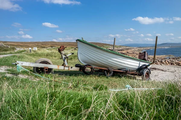 Vissersboot op een roestige trailer bij de oceaan — Stockfoto
