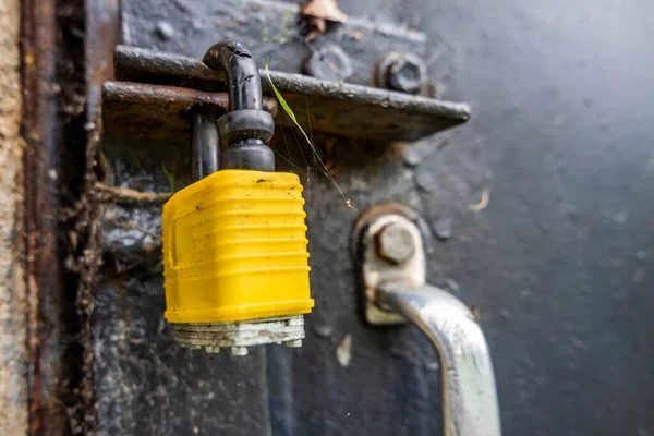 Gesloten geel slot bij zwarte stalen deur met handvat — Stockfoto