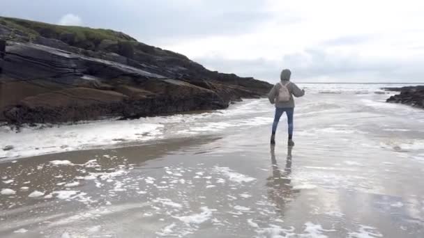 Леді грає смішний танець на пляжі. — стокове відео
