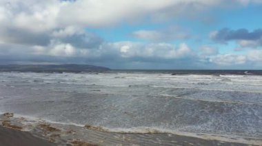 Kuzey İrlanda 'daki County Londonderry' deki güzel Downhill plajında okyanusun üzerinde uçuyor.