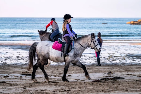 BURTONPORT, COMTÉ DE DONÉGAL, IRLANDE - 18 DÉCEMBRE 2021 : La famille de pupilles monte ses chevaux sur la plage — Photo