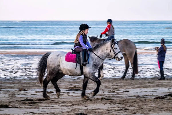 BURTONPORT, COMTÉ DE DONÉGAL, IRLANDE - 18 DÉCEMBRE 2021 : La famille de pupilles monte ses chevaux sur la plage — Photo
