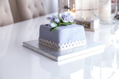 Mavi güllerle süslenmiş güzel meyveli pasta.