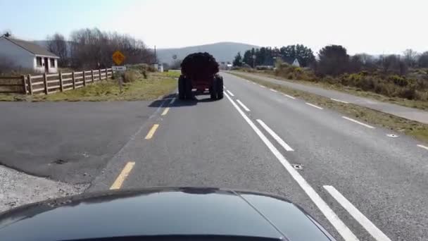 Трактор, перевозящий торф на прицепе в графстве Донегал - Ирландия — стоковое видео