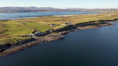 Ballysaggart rıhtımının ve 15. yüzyıl Fransisken Üçüncü Düzen 'inin hava manzarası County Donegal, İrlanda' daki St Johns Point 'te kaldı..