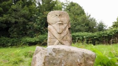 This is a bronze age stone carviing with two faces,called Janus, located In Caldragh Cemetery on Boa Island, Lower Lough Erne. Northern Ireland.