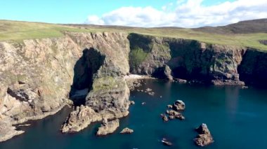 İrlanda 'nın Donegal ilçesindeki Arranmore adasındaki deniz fenerinin yakınındaki uçurumların havadan görüntüsü..