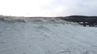 Rüzgâr Narin Caddesi 'ndeki kum tepelerini havaya uçuruyor Portnoo, County Donegal - İrlanda