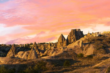 Antik kentin yakınlarındaki mağaralar ve güneş doğduktan sonra bir dağdan kazılan Uchisar kalesi, Kapadokya, Türkiye.