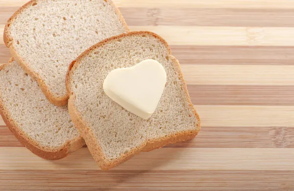 Bread and heart shaped butter — Stock Photo, Image