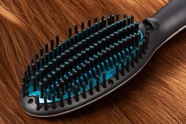 Kızıl saçlarda elektrikli saç düzleştirici fırça