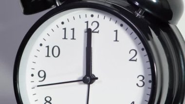 Siyah alarm saati beyaz arkaplanda izole edilmiş. Saat 12: 00 'yi gösteriyor