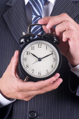 adam bir çalar saat tutar