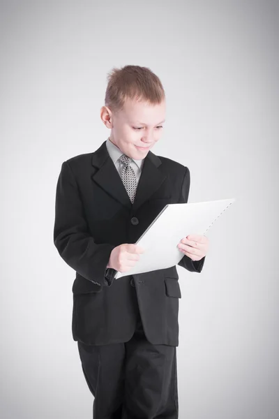 Jongen kijkt naar de stapel papier — Stockfoto