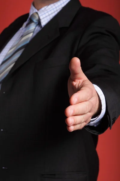 Business man open hand ready to seal a deal red background — Stock Photo, Image