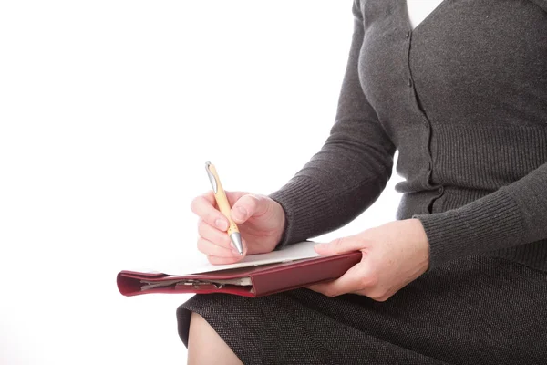 Mujer en gris escribir por pluma sobre papel. Señas de mujer de negocios. Aislado sobre fondo blanco — Foto de Stock