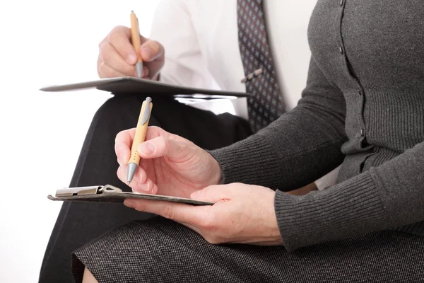 Donna e uomo in grigio scrivono a penna su carta. Le donne d'affari firmano. Isolato su sfondo bianco — Foto Stock