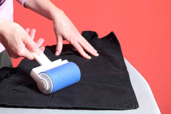 Kvinna hand rengöring damm med lint roller — Stockfoto