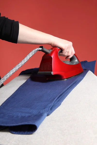 Huishoudelijke taken - rood ijzer in hand en Marine blauw shirt — Stockfoto