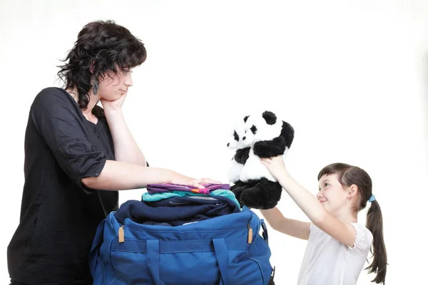 Mulher e filha mão apertada cheia de roupas e bolsa de ombro — Fotografia de Stock