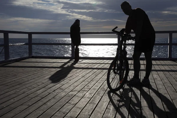Άνθρωπος με ποδήλατο στην αποβάθρα, προβλήτα στη θάλασσα το πρωί — Φωτογραφία Αρχείου