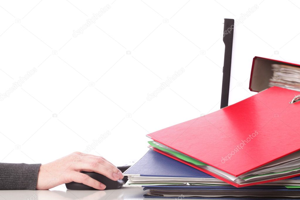 Businesswoman - woman hand on mouse pen and computer. Pile of folders with old documents and bills.