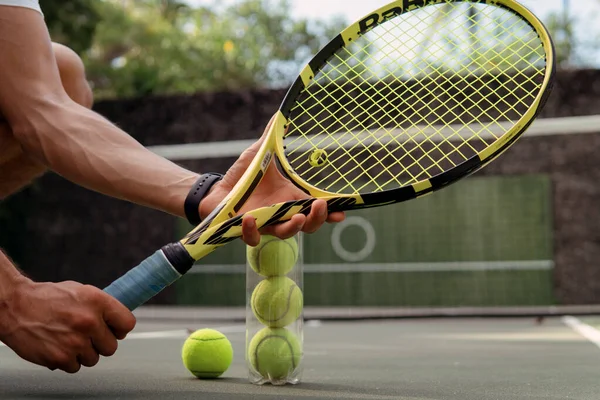 stock image close-up. male hands holding tennis racket and balls