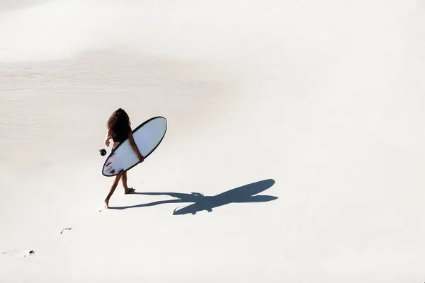 Frauen spazieren mit Surfbrett im Sand — Stockfoto