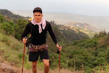 Bir adam dağlarda yürüyor.