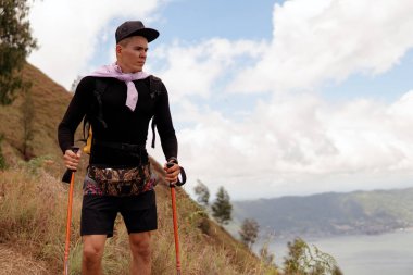 Bir adam dağlarda yürüyor.