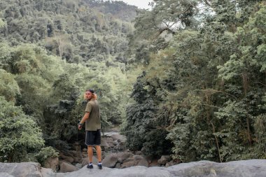 Fotoğrafçı kayaların üzerinden yürür.