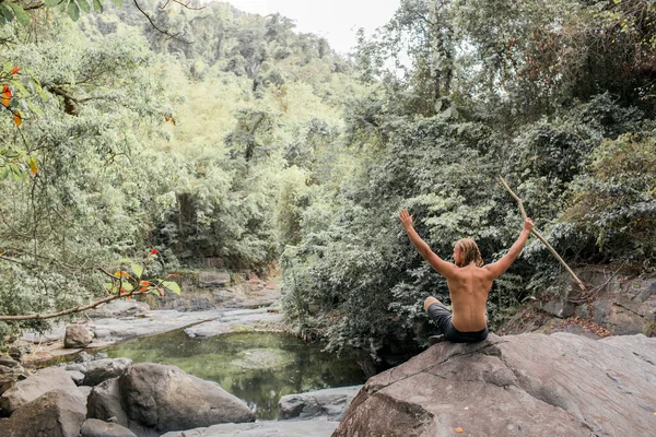 Turista senta-se em uma pedra na floresta. — Fotografia de Stock