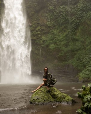 Şelalenin arka planında poz veren kadınlar.