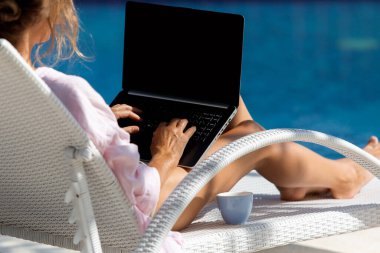 Havuzun yanındaki bilgisayarda çalışan güzel bir kadın. yüksek kaliteli fotoğraf