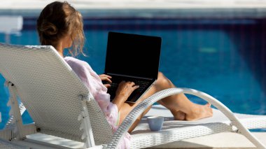 Havuzun yanındaki bilgisayarda çalışan güzel bir kadın. yüksek kaliteli fotoğraf