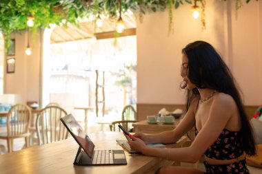 Kafede oturup tablet üzerinde çalışan güzel bir kadın. bali