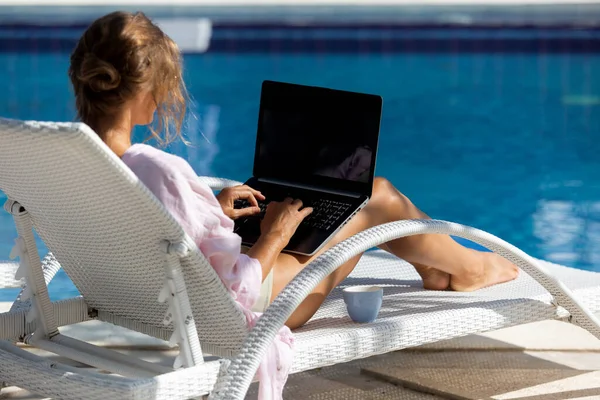 Havuzun yanındaki bilgisayarda çalışan güzel bir kadın. yüksek kaliteli fotoğraf