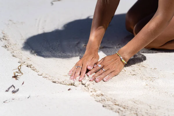 Όμορφα θηλυκά χέρια σε λευκή άμμο Royalty Free Εικόνες Αρχείου