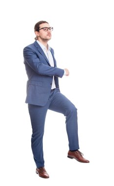 Kendine güvenen işadamı beyaz arka planda izole edilmiş yaratıcı bir merdivene tırmanıyor. Kariyer gelişimi ve hedef başarısı kavramı. Uzun boylu iş adamı büyük bir adım attı.