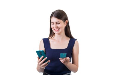 Diğer elinde kredi kartı tutarken akıllı telefonunu kullanan mutlu genç bir kadın. Fotokopi çekilen beyaz arka planda izole edilmiş. Çevrimiçi mobil bankacılık kavramı