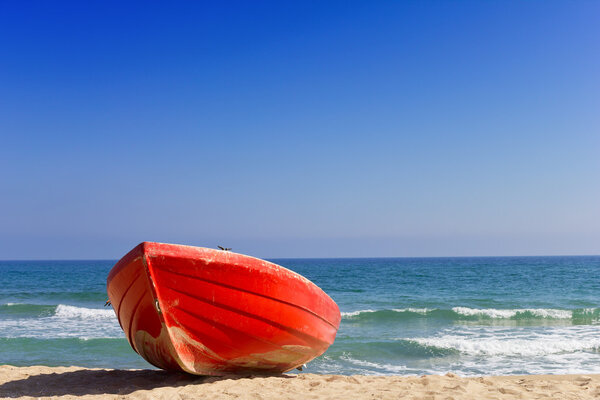 красная лодка на пляже
