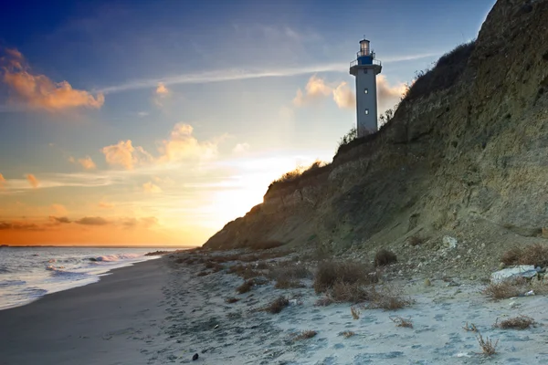 Praia rochosa com farol — Fotografia de Stock