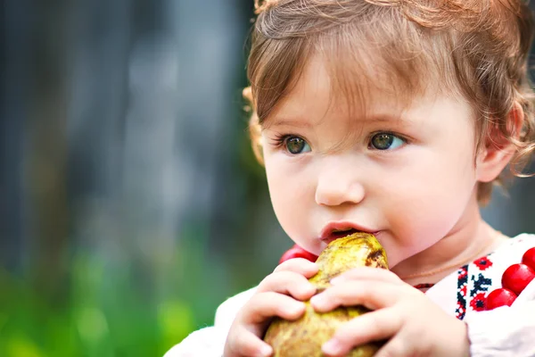 Ragazza mangiare una pera — Foto Stock