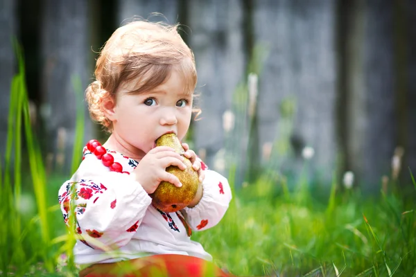 Chica bonita comiendo una pera — Foto de Stock